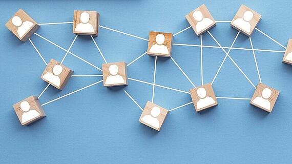 Wooden blocks connected together on a blue background. Teamwork concept