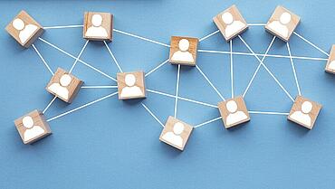 Wooden blocks connected together on a blue background. Teamwork concept